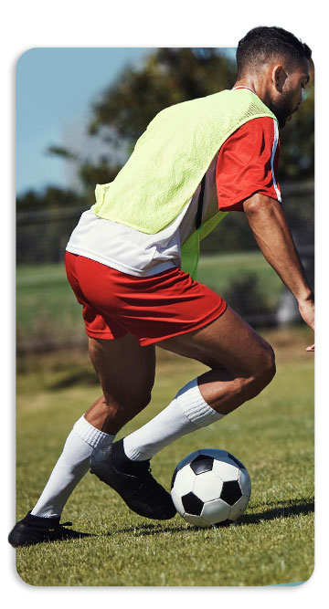 Atleta jogando futebol, feliz após uma infiltração e ações de medicina regenerativa