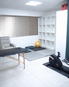 Área de reabilitação. Tatames no chão, bolas de pilates, bicicleta ergométrica e maca
